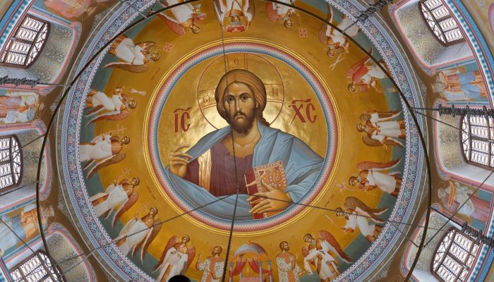 Vibrant fresco of a haloed central figure surrounded by cherubic angels — a depiction from the Christian artistic tradition